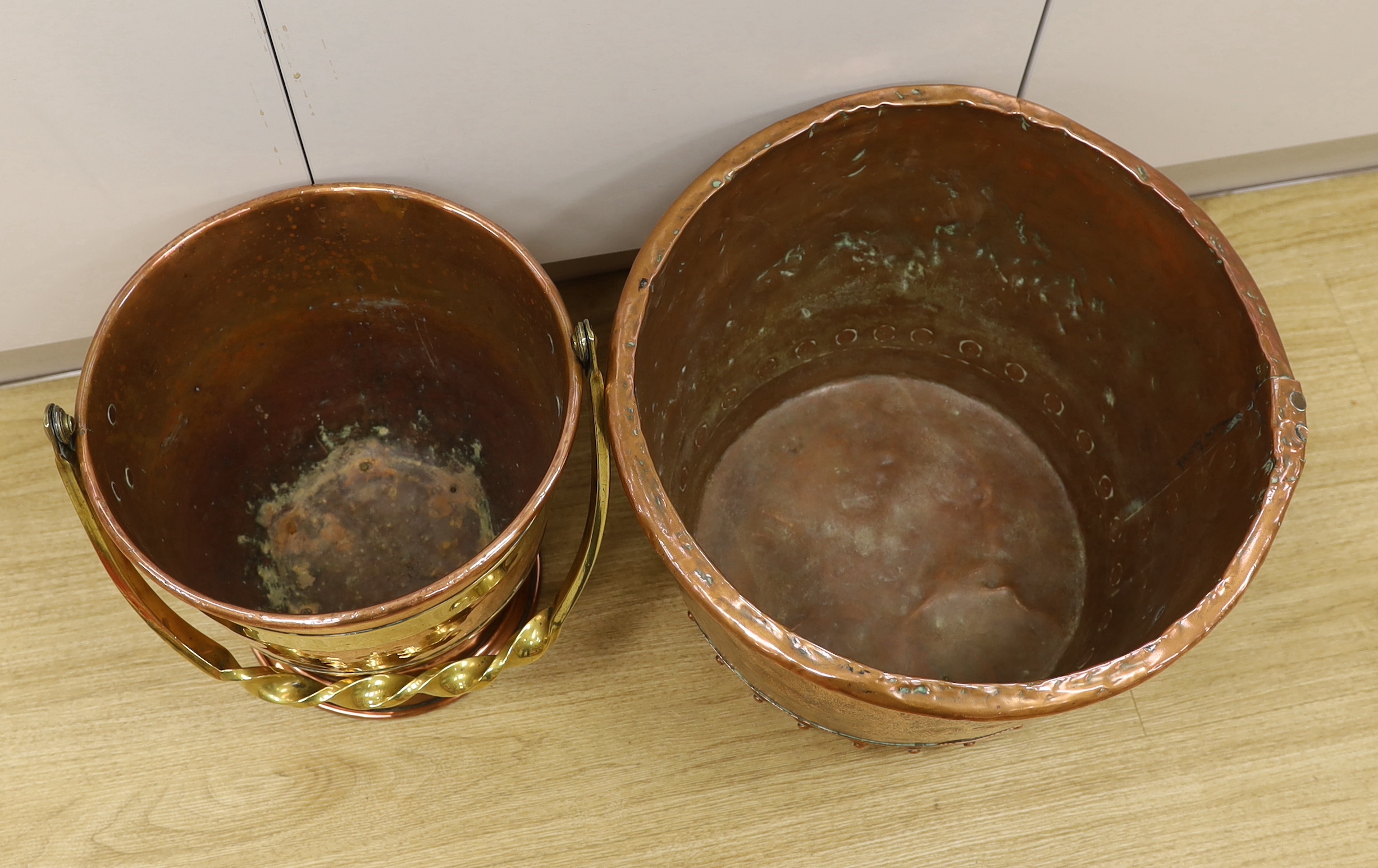 An Arts and Crafts copper and brass bucket, together with a copper embossed pot, both 30cm high